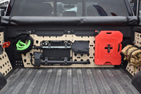 Forged Authority Tan MOBUL F-150 Header Panel, used to securely store tools and gear in your truck bed, featuring storage of a snatch strap, our RotoPax Adapter accessory, and our Tool Board securing a shovel and axe.