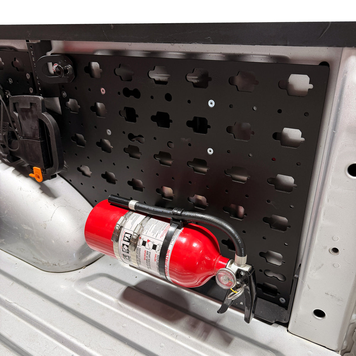 Fire Extinguisher Mount, mounted horizontally on a MOBUL panel in a truck bed.