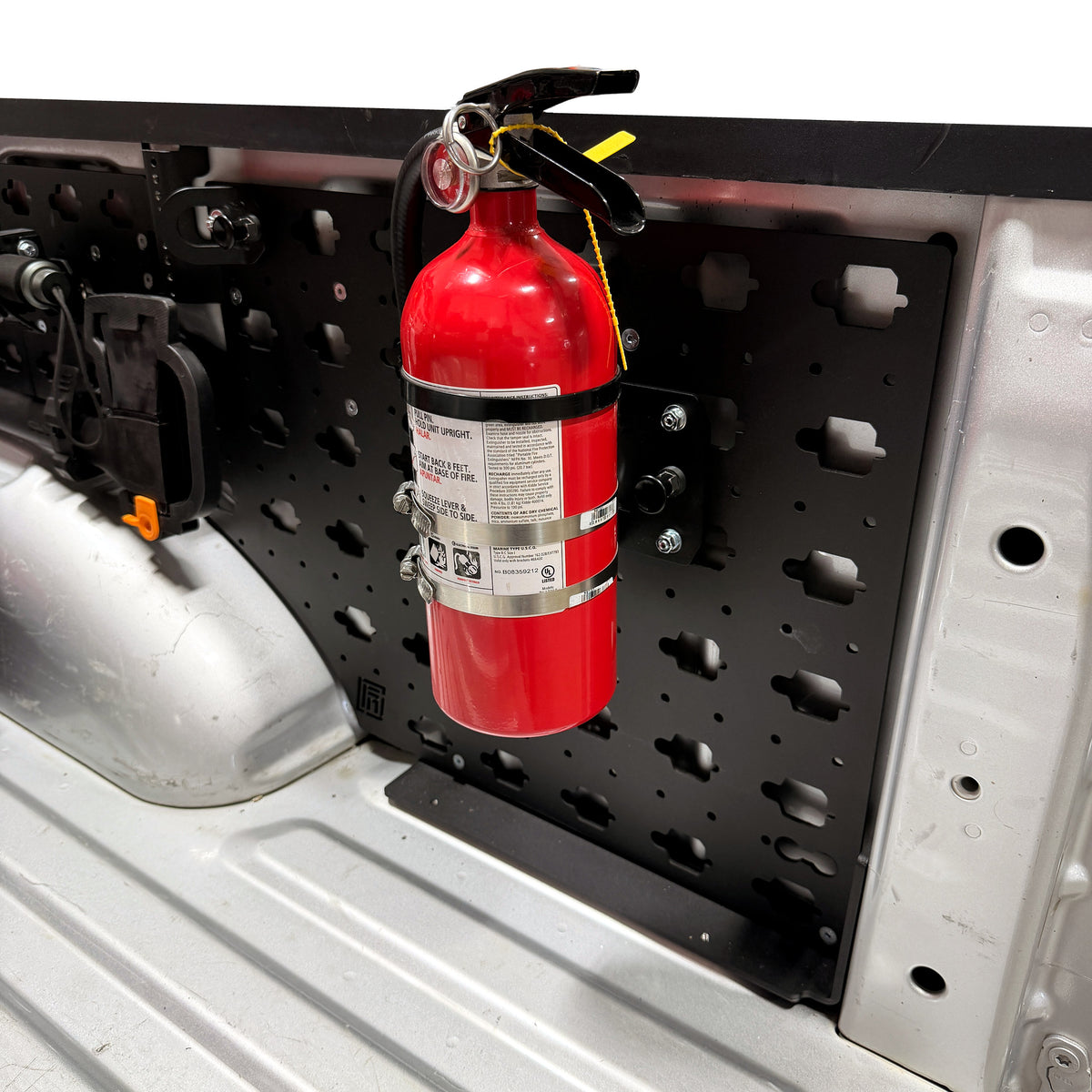 Fire Extinguisher Mount, mounted vertically on a MOBUL panel in a truck bed.