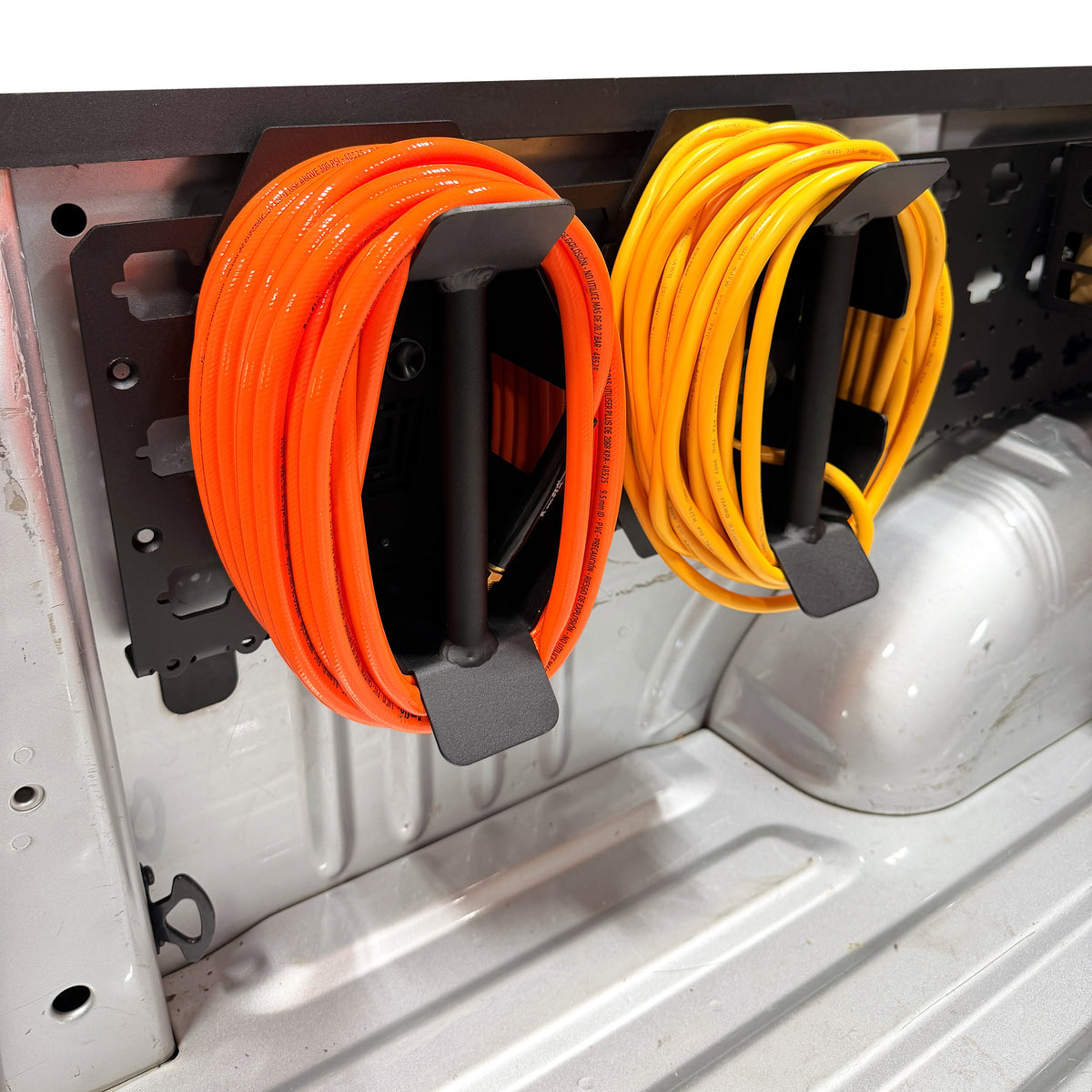 MOBUL Cord & Hose Wrap Mount, two wraps with cords on a MOBUL panel in a truck bed.