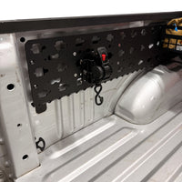 MOBUL Retractable Ratchet Strap Mount, strap retracted, on a MOBUL panel in a truck bed.
